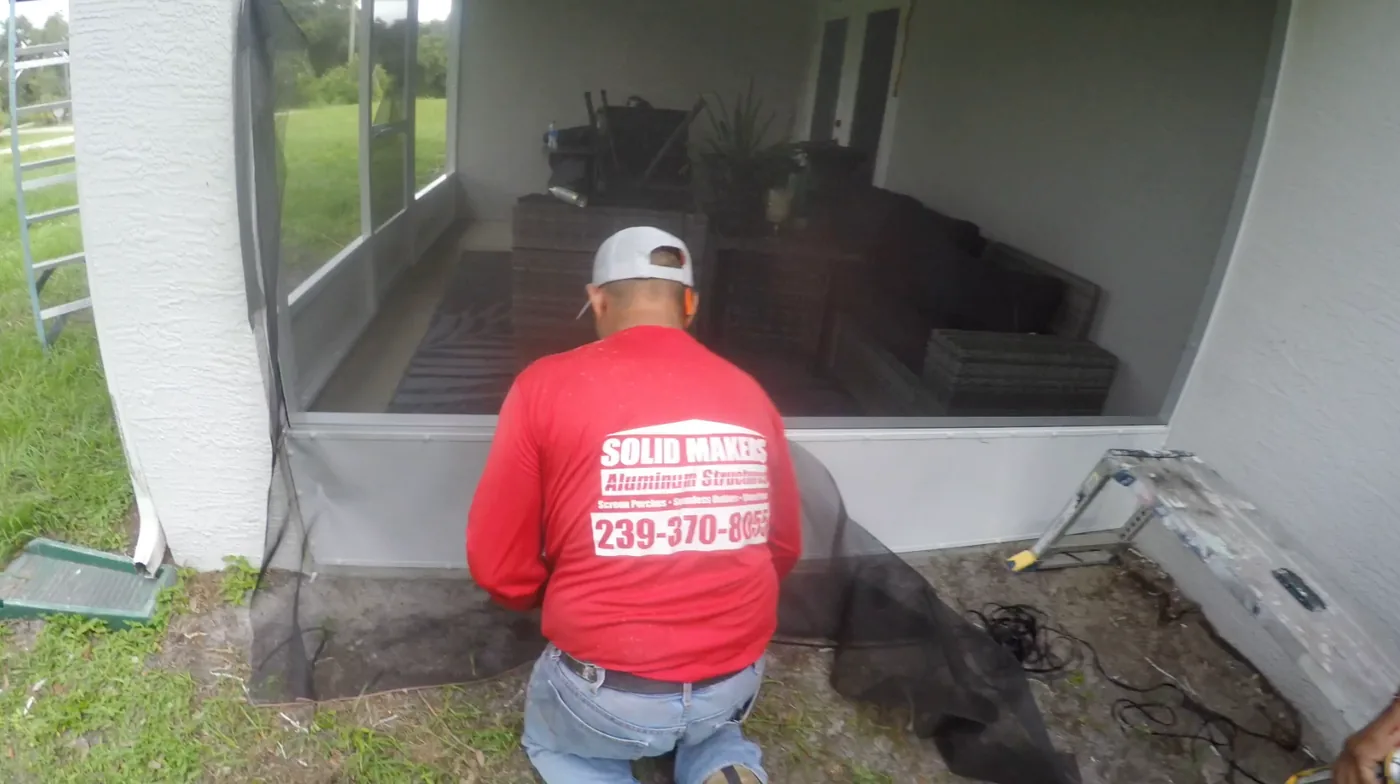 Solid Makers installing new screen during a screen lanai repair in Port LaBelle Florida