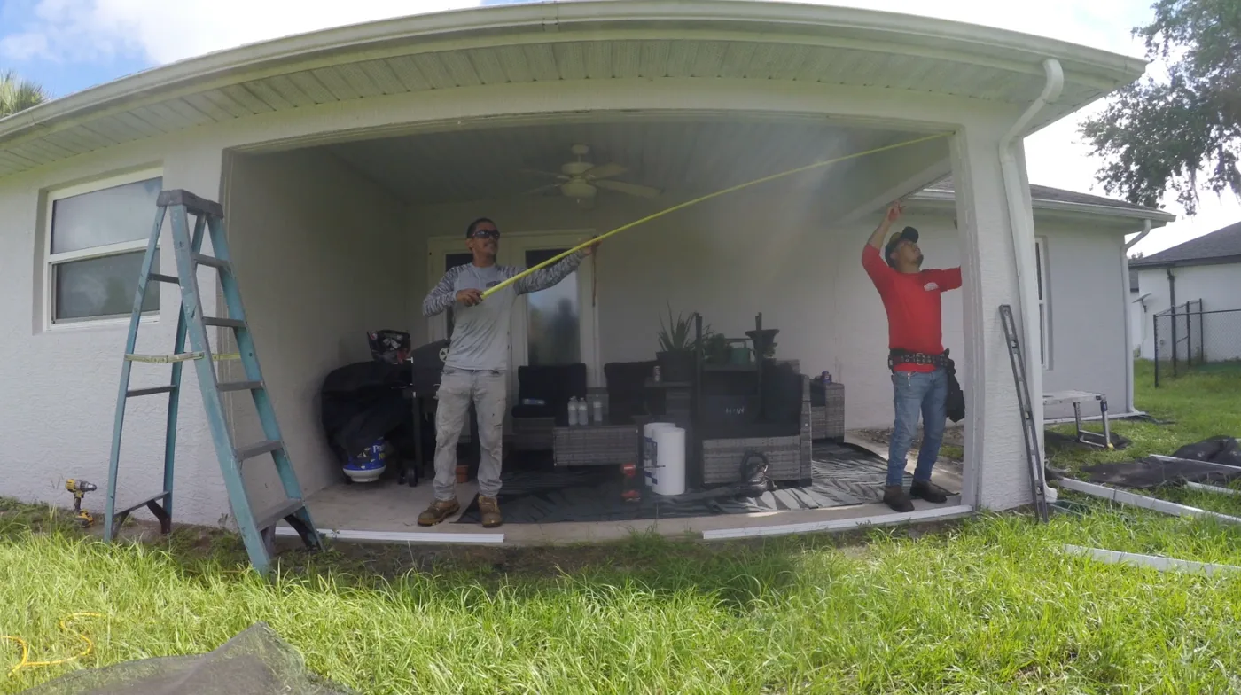 Solid Makers crew measuring for new aluminum framing during a screen lanai rebuild in Port LaBelle Florida